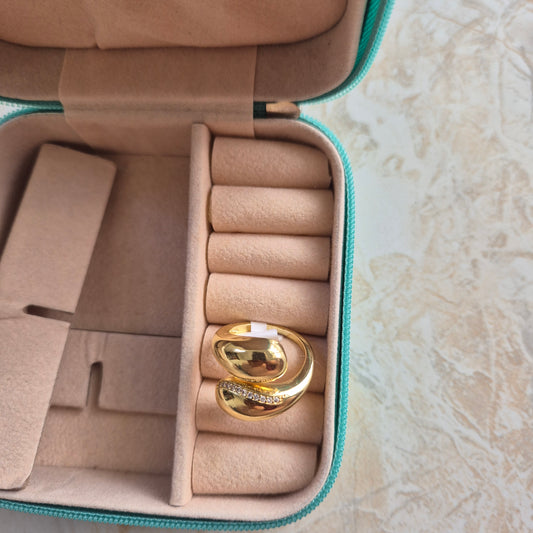 Gold earrings in a jewelry case on a marble background