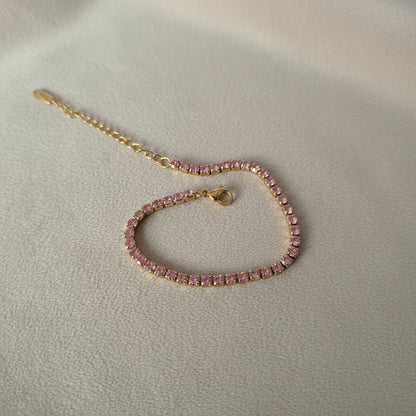 Pink beaded bracelet with a gold clasp on a white background