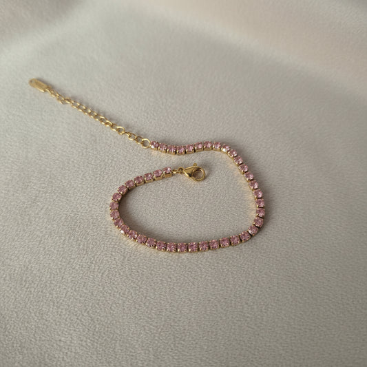 Pink beaded bracelet with a gold clasp on a white background