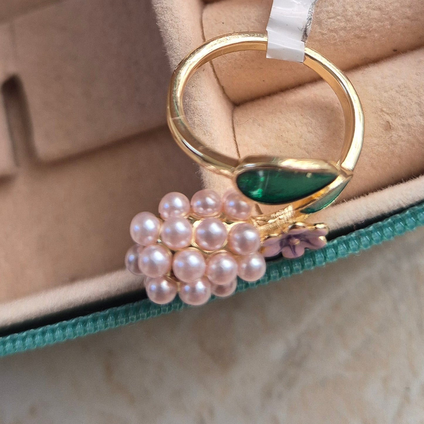 Gold ring with pearl grapes on a jewelry case